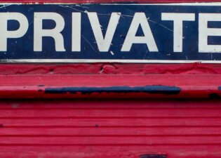 A red mail slot with a sign reading PRIVATE above it